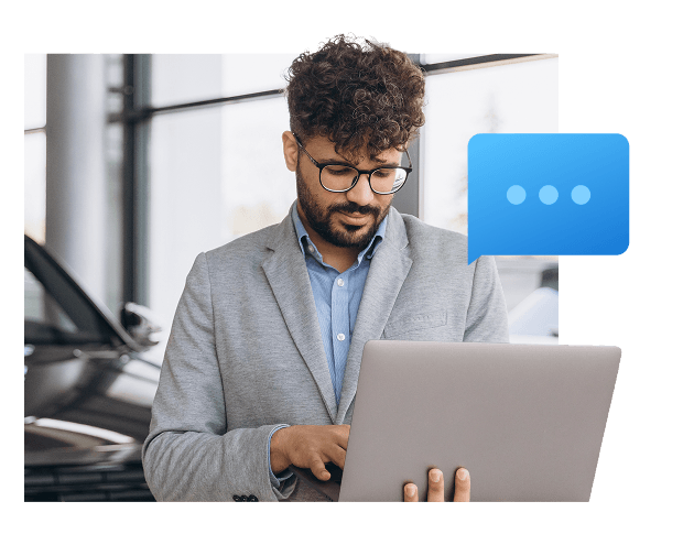Automotive dealership employee managing customer messages on a laptop